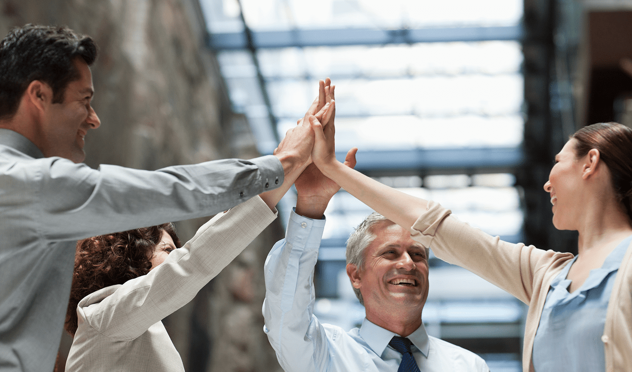 Group high-fiving in office