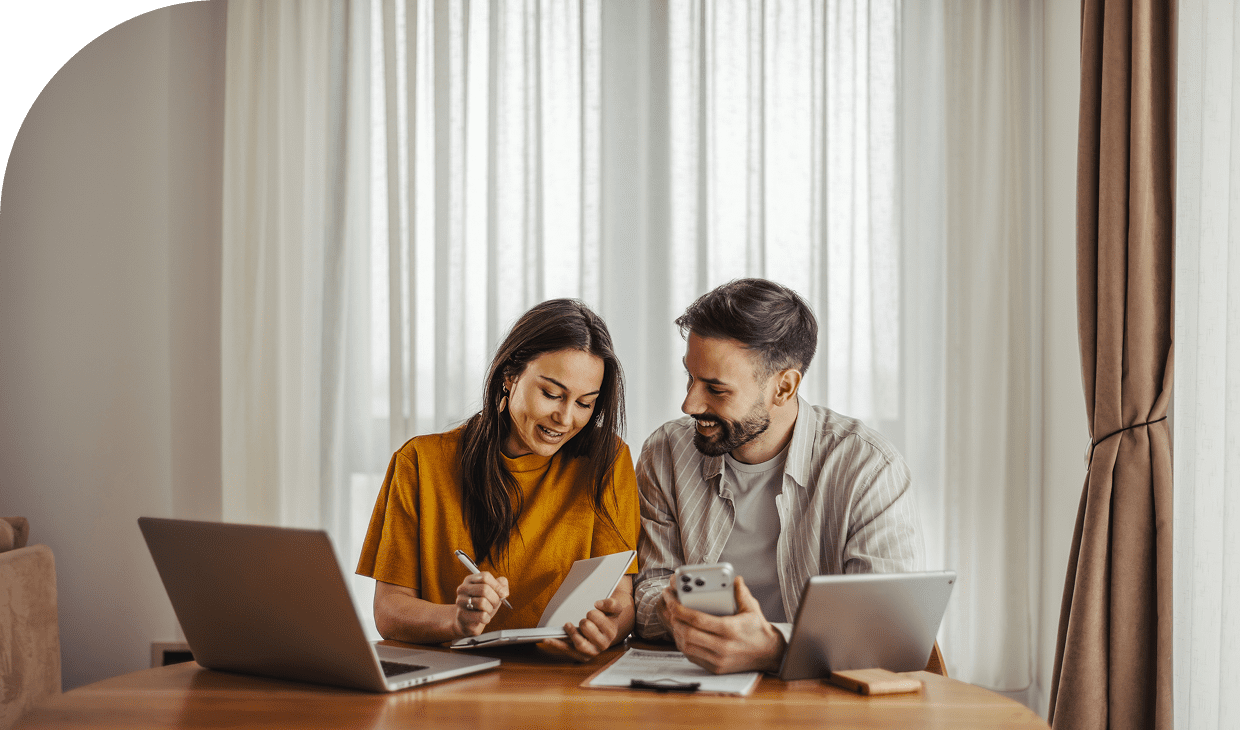 Happy couple using laptops and phones