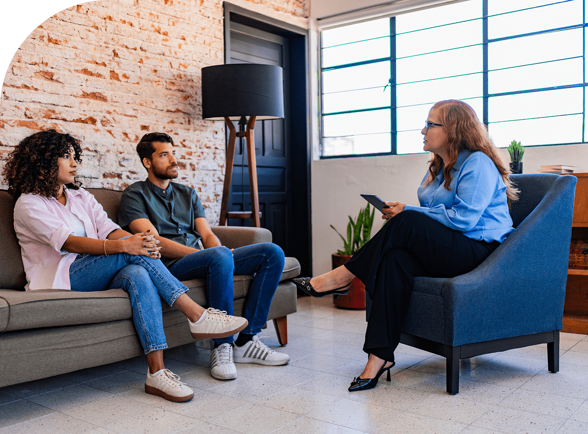 Therapist talking to couple on couch.