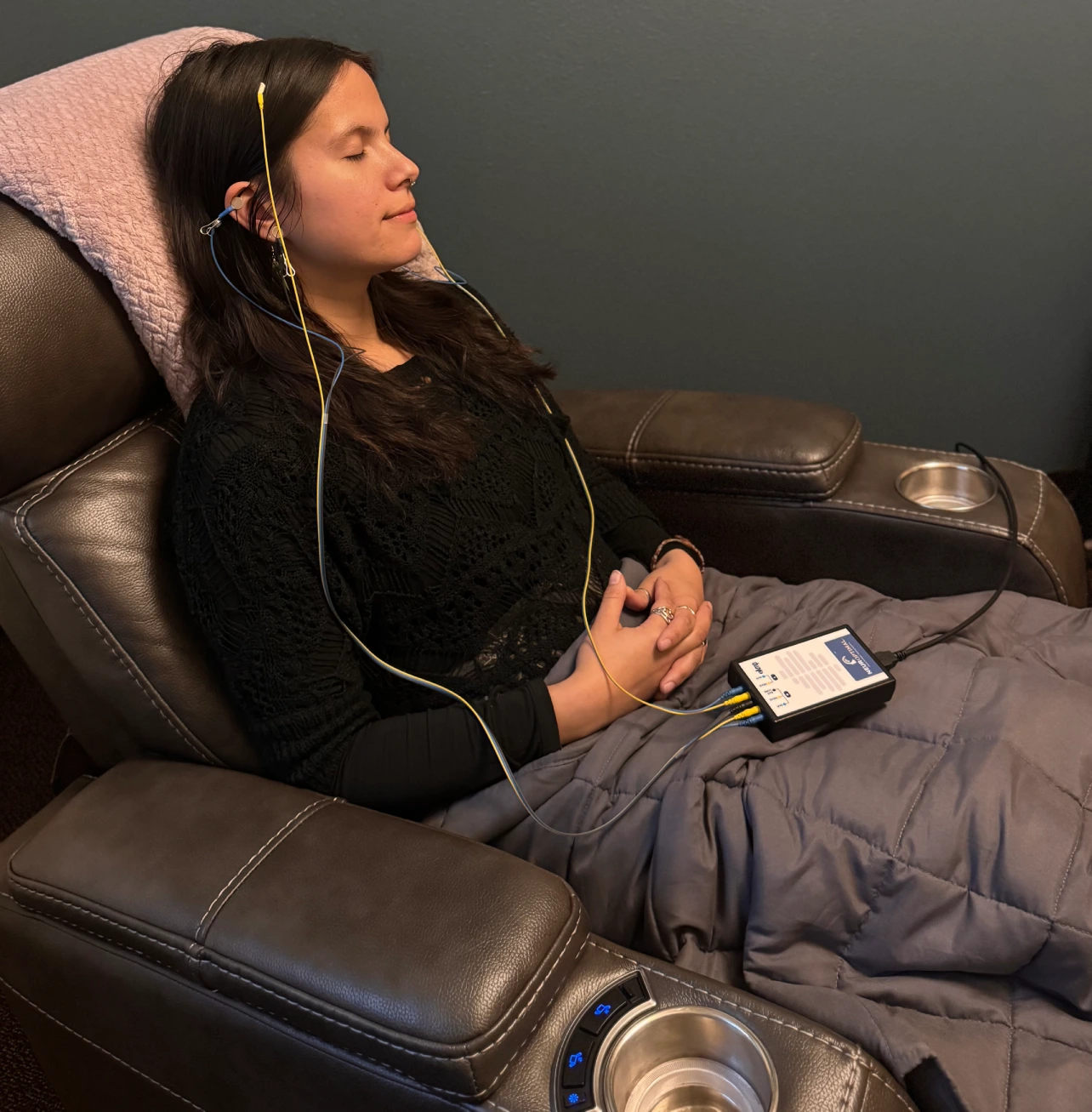Person reclined with electrodes and monitoring device