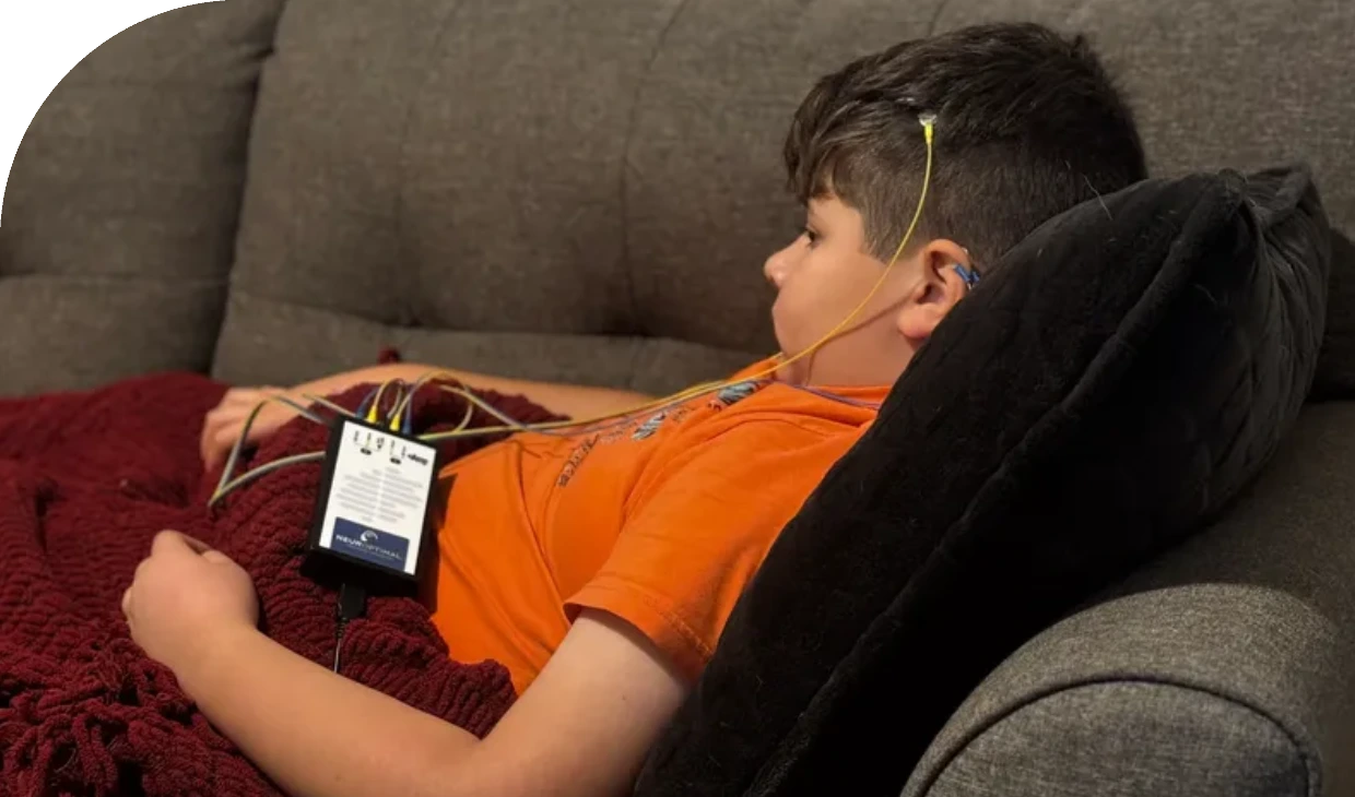 Child reclining on couch with monitoring device