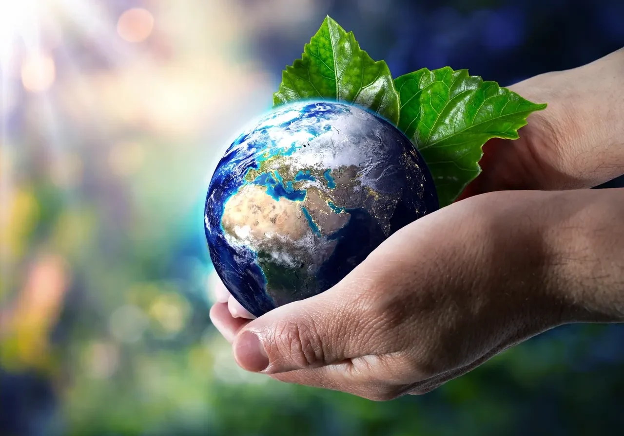 Hands holding Earth with leaves